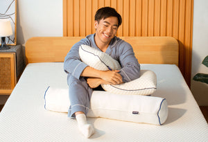 Man hugging Sonno Memory Foam Pillow on Sonno Original Mattress in a Japandi bedroom